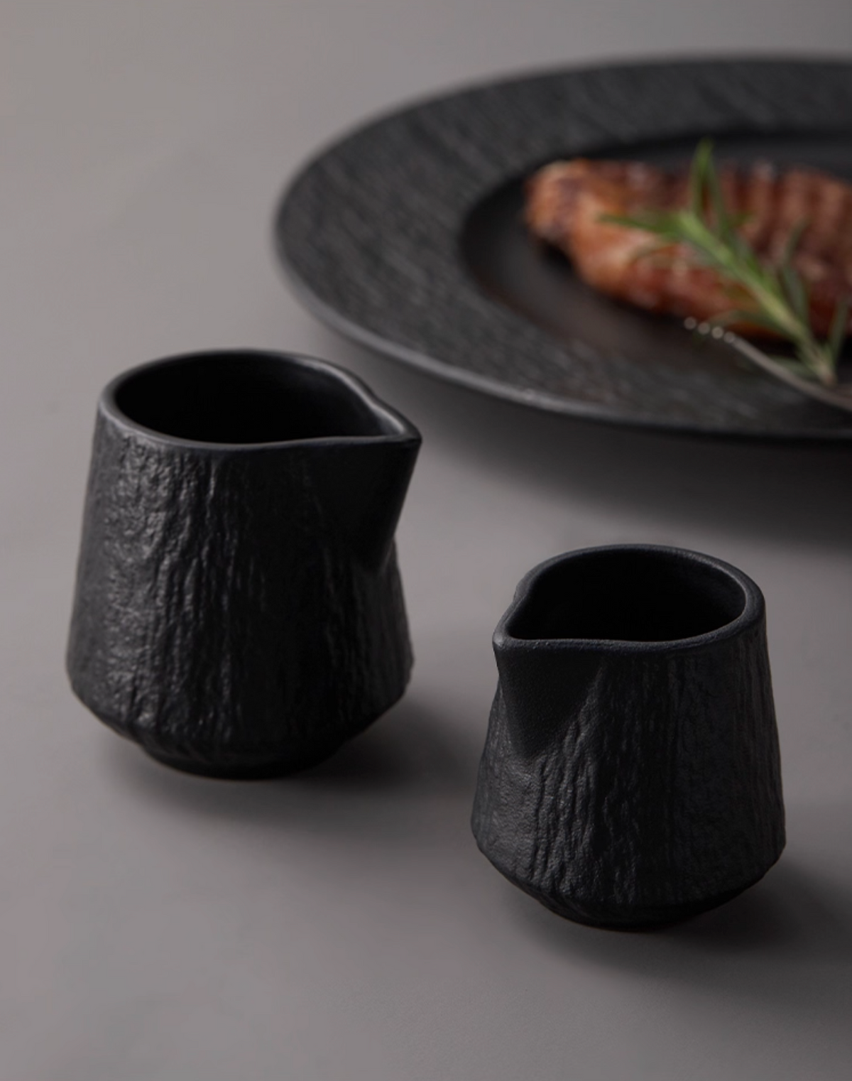 Side view ceramic sauce pourer showing ergonomic handle design